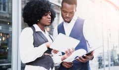 portrait-young-african-businesswoman-showing-something-digital-tablet-her-colleague_23-2148190652