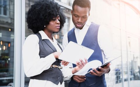 portrait-young-african-businesswoman-showing-something-digital-tablet-her-colleague_23-2148190652