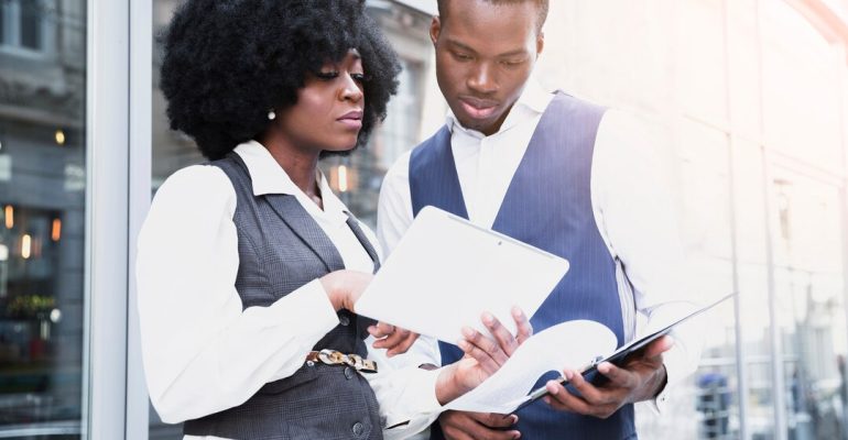 portrait-young-african-businesswoman-showing-something-digital-tablet-her-colleague_23-2148190652